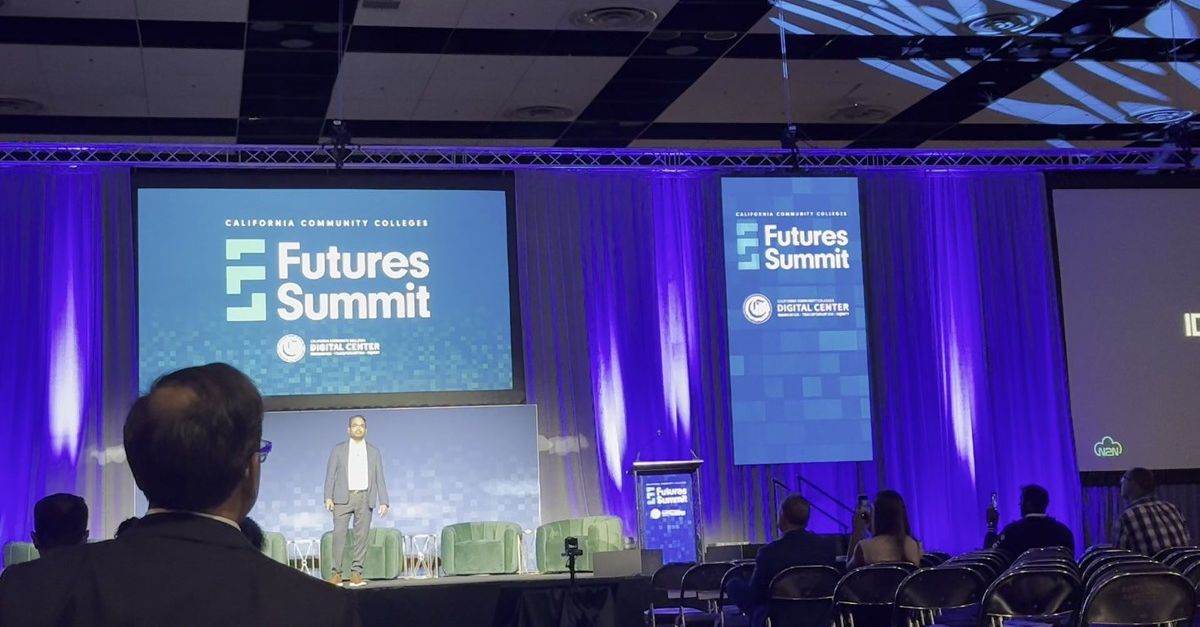 Kiran Kodithala on stage at the California Community Colleges' Futures Summit 2026, with the Futures Summit + CCC Digital Center banners behind him and a Meridian screen on the projector — captioned 'How to build your first AI product.'